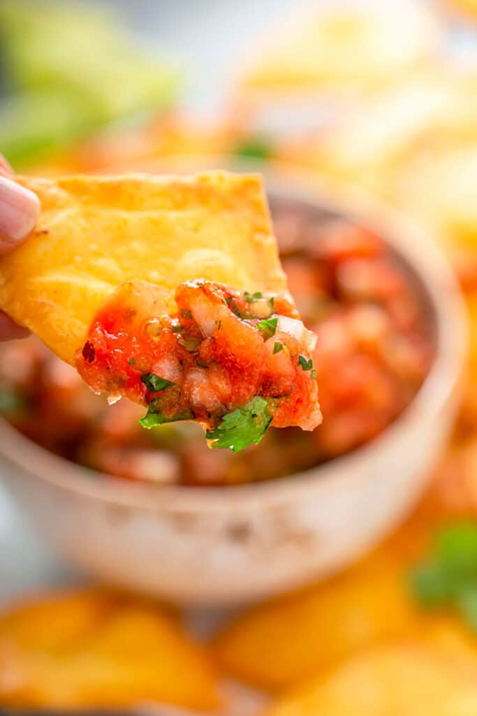 close up view of a homemade tortilla chip with mexican salsa