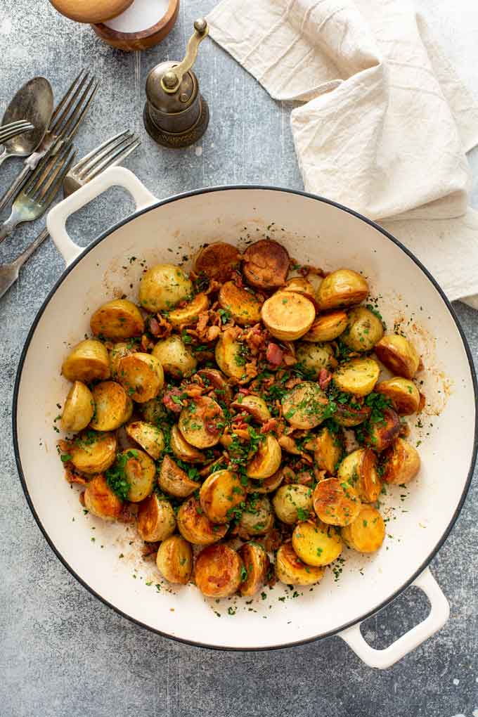 Crispy red potatoes with herbs and bacon in a skillet