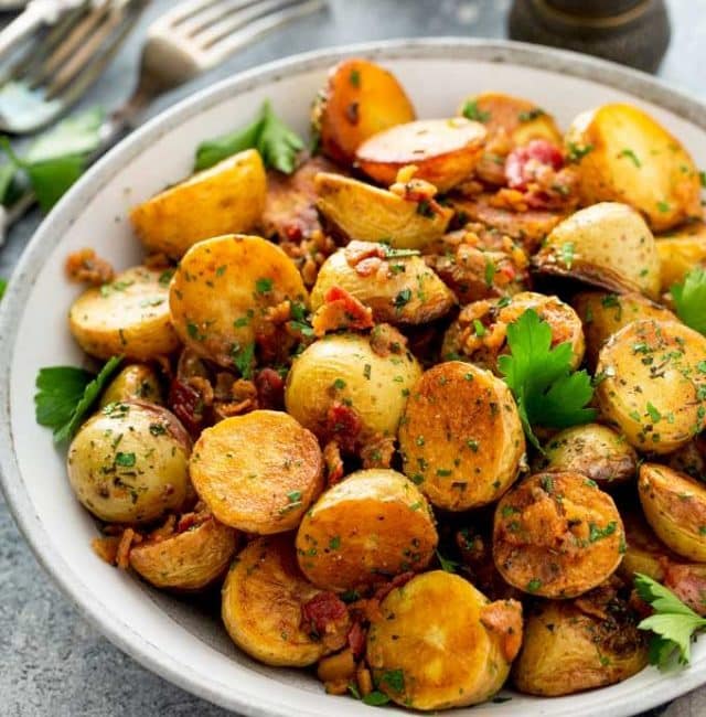 A serving bowl filled with golden sautéed potatoes