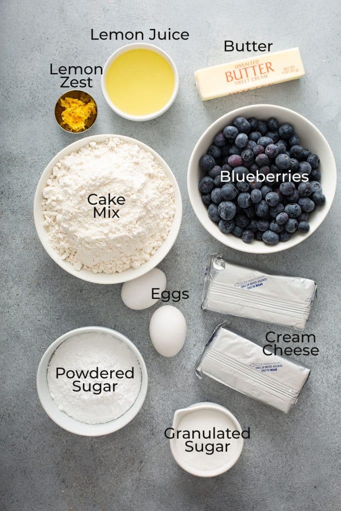 Ingredients to make lemon blueberry crumble bars on a gray surface