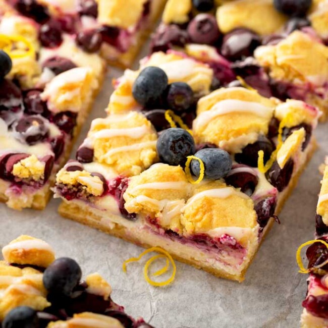 Lemon Blueberry crumb bars cut into squares on a piece of parchment paper