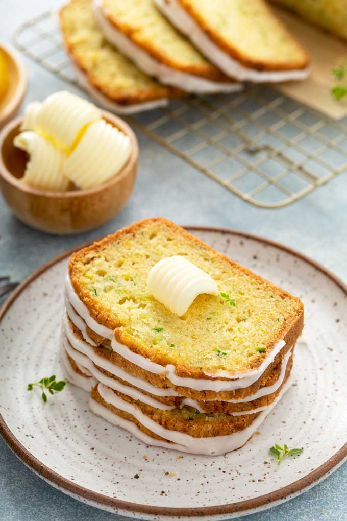 Slices of bread topped with a pad of sweet butter on a plate