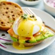 Smoked Salmon eggs Benedict with sliced avocado on a white plate