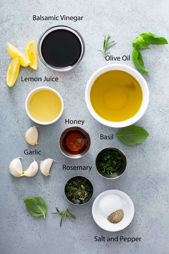 Ingredients to make balsamic marinade for chicken breast on a gray surface