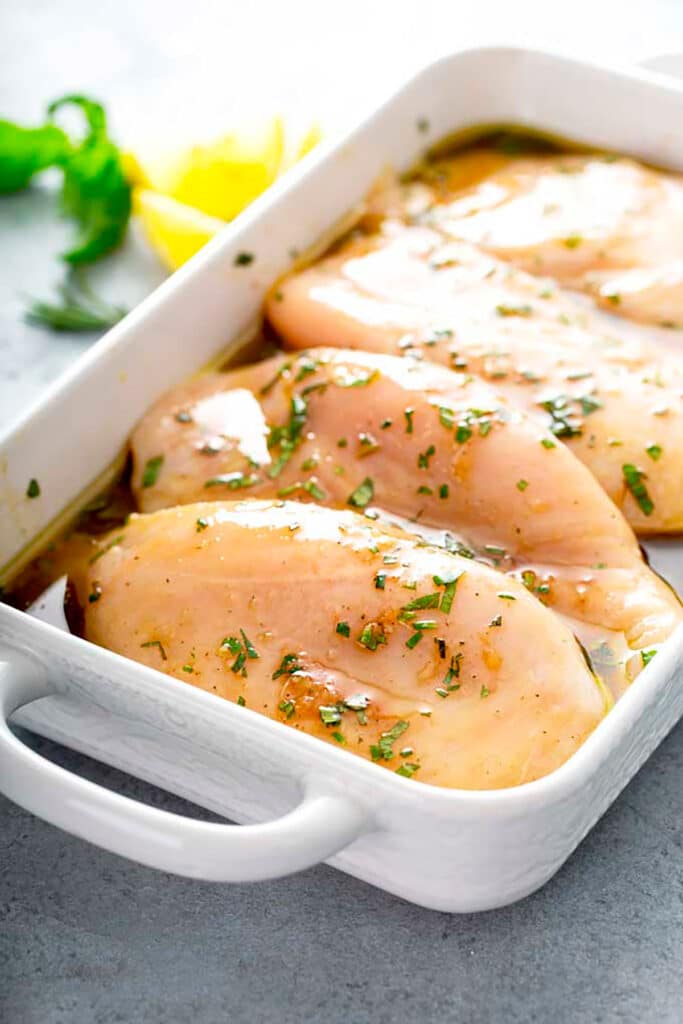 4 Chicken breasts marinating on balsamic in a white casserole