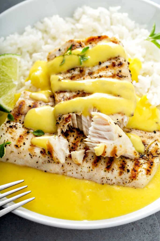 Flaking fish with a fork. Grilled Mahi Mahi with Mango Lime Sauce - lemon Blossoms