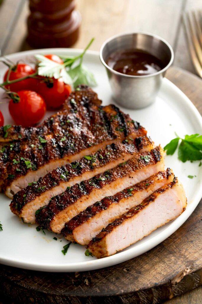 Tender and juicy sliced pork chops on a white plate.