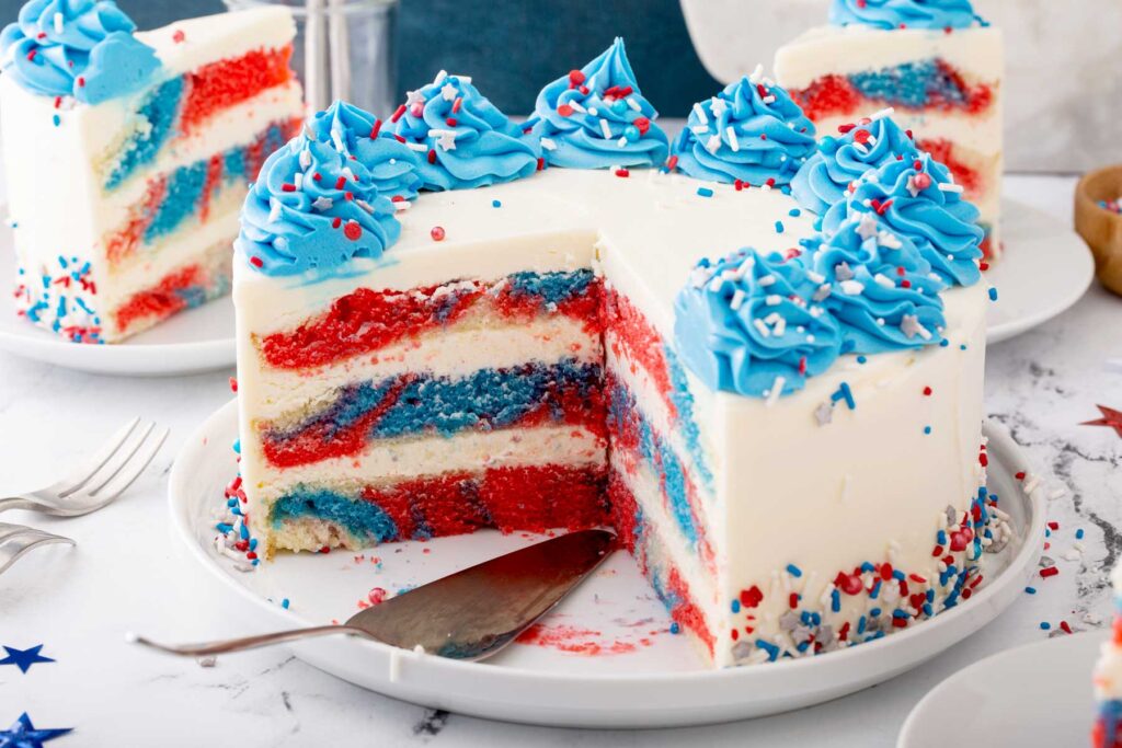 Whole frosted Patriotic cake with a few slices cut off