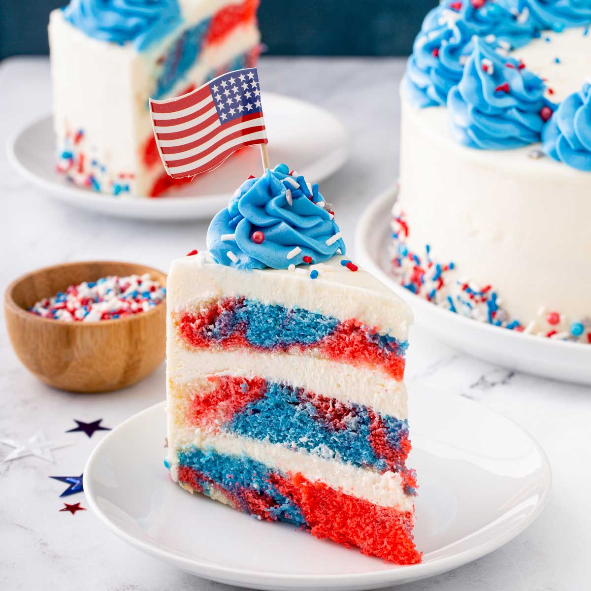 Sliced of Red White and Blue Marbled Layered Cake with frosting on a plate