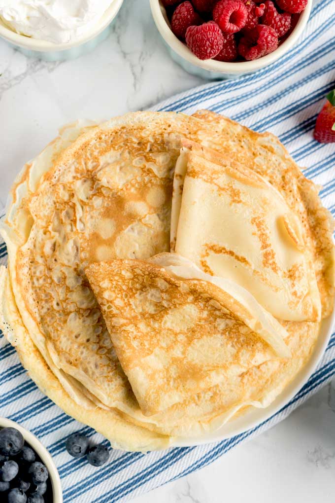 A plate piled up with easy to make crepes.