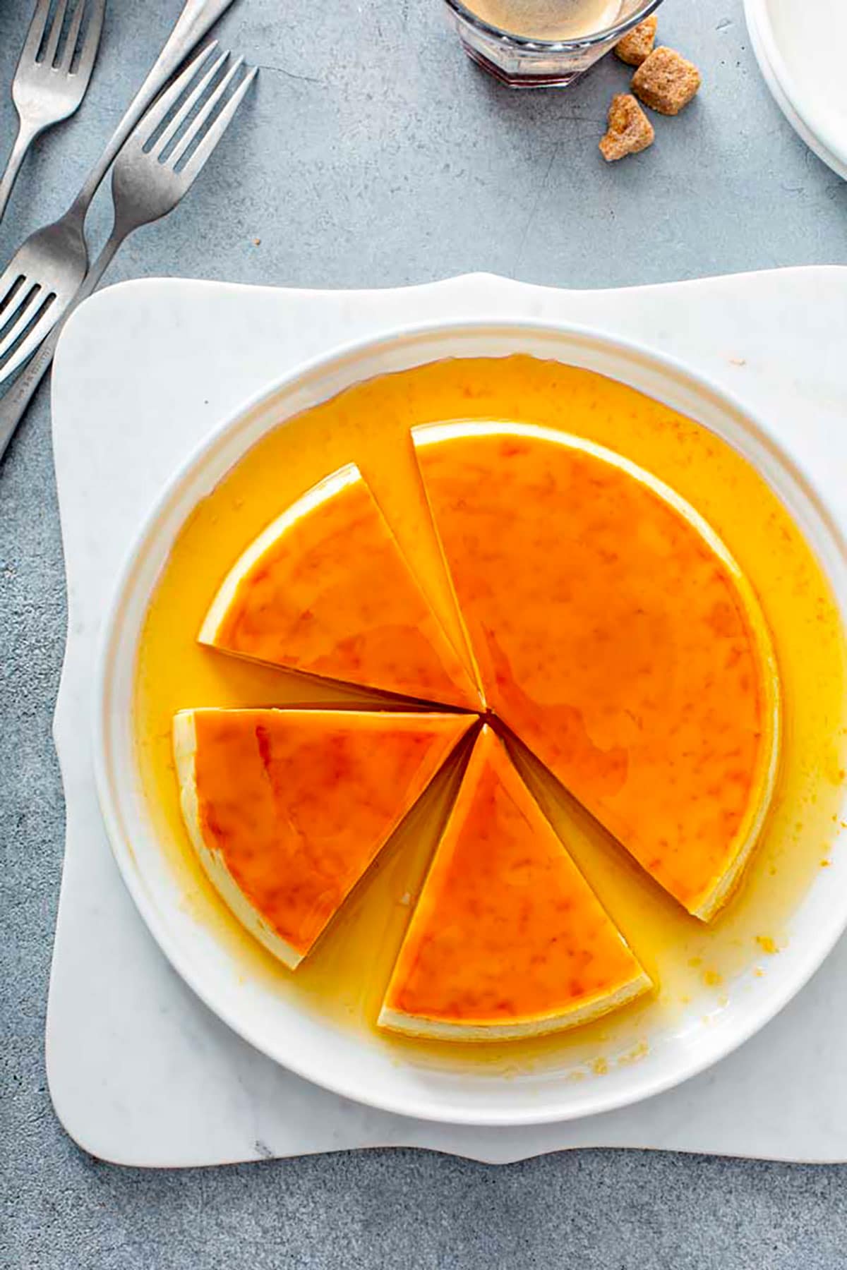 Top view of a caramel flan sliced on a white plate