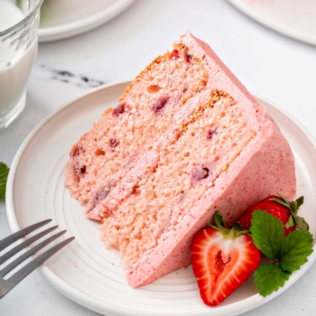 A slice of fresh strawberry cake with buttercream
