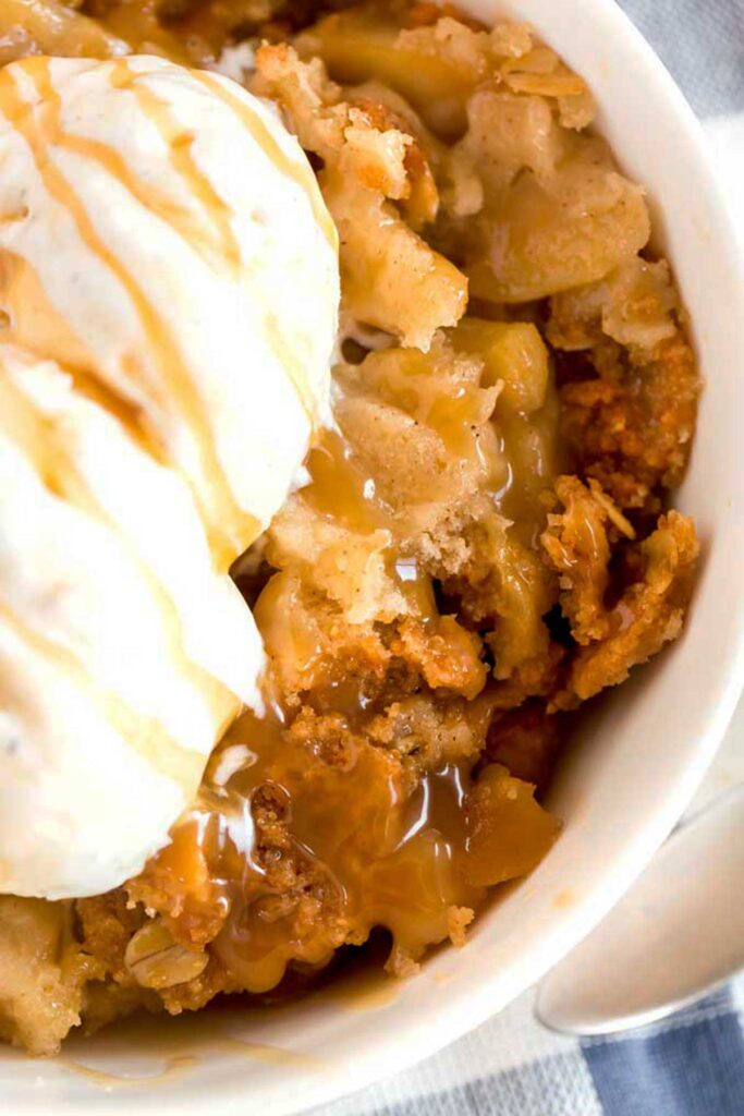 Warm apple crisp topped with ice cream and caramel swirl
