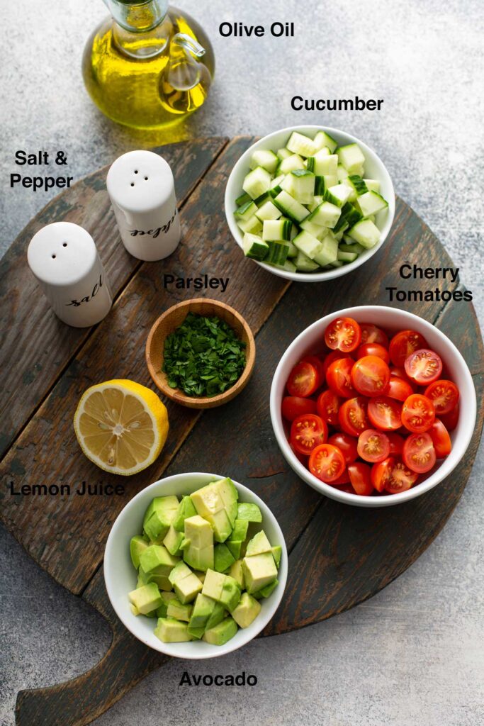 Fresh ingredients to make a chopped salad to top fish (avocado, cucumber, tomatoes)