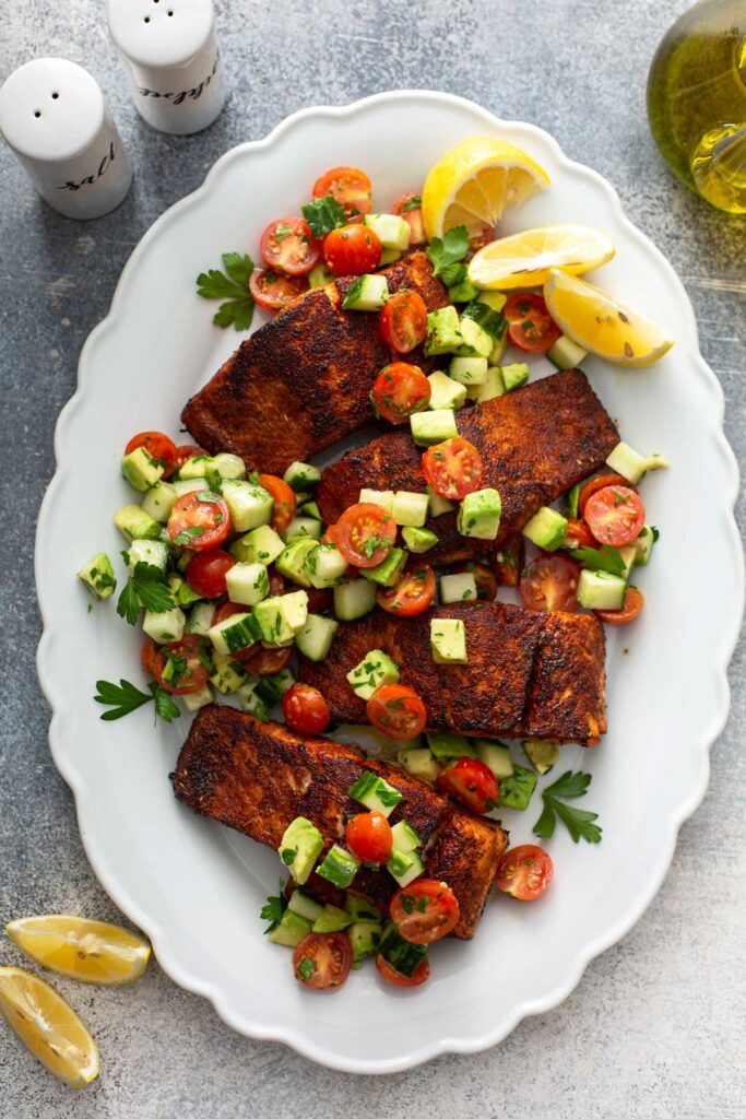 Pan seared fillets of salmon coated in blackening spices and topped with a fresh chopped salad 