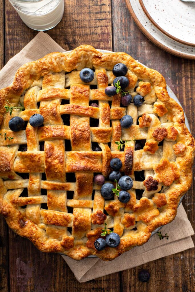Top view of a whole blueberry pie with a lattice golden brown pie crust