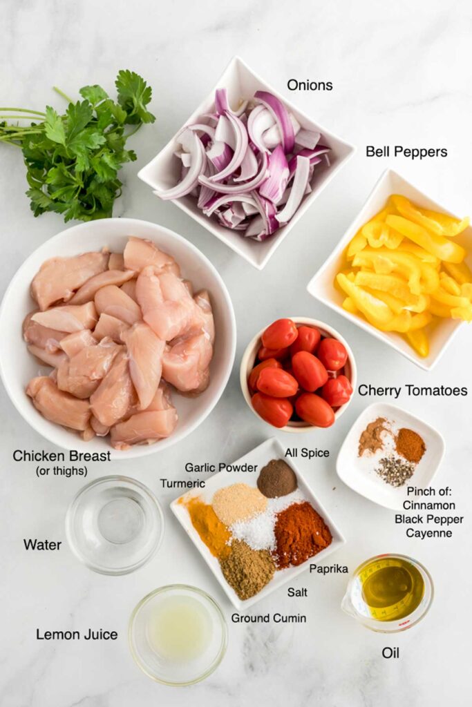Ingredients needed to make sheet pan shawarma with veggies on a white surface