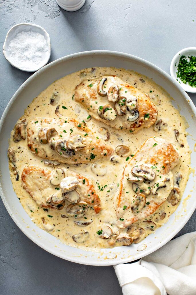 Creamy Chicken and Mushrooms in a white skillet ready to be served