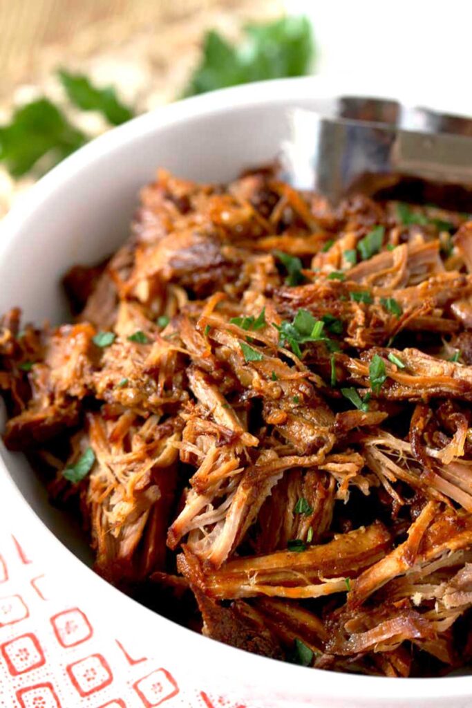 Shredded BBQ pulled pork in a white bowl