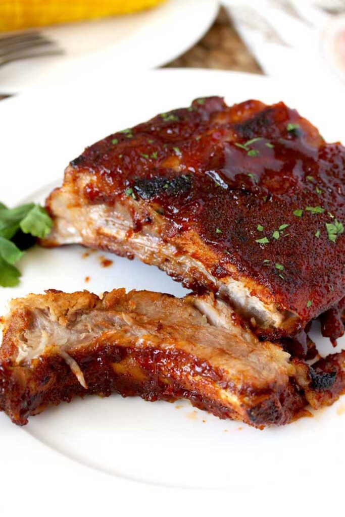 Small rack of baby back ribs with BBQ sauce on a plate
