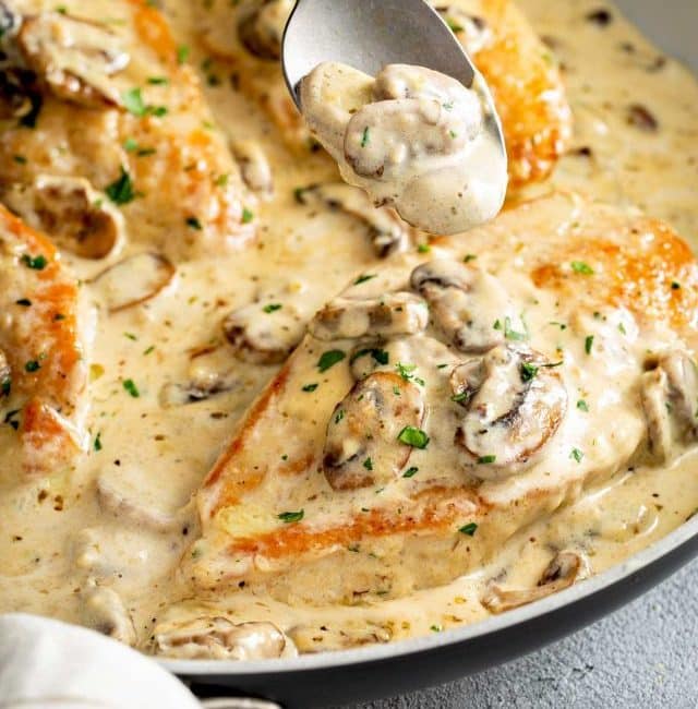 Chicken cutlets with mushrooms in a creamy sauce inside a skillet