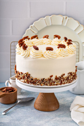Butter Pecan cake frosted with cream cheese frosting and decorated with chopped and whole toasted pecans.