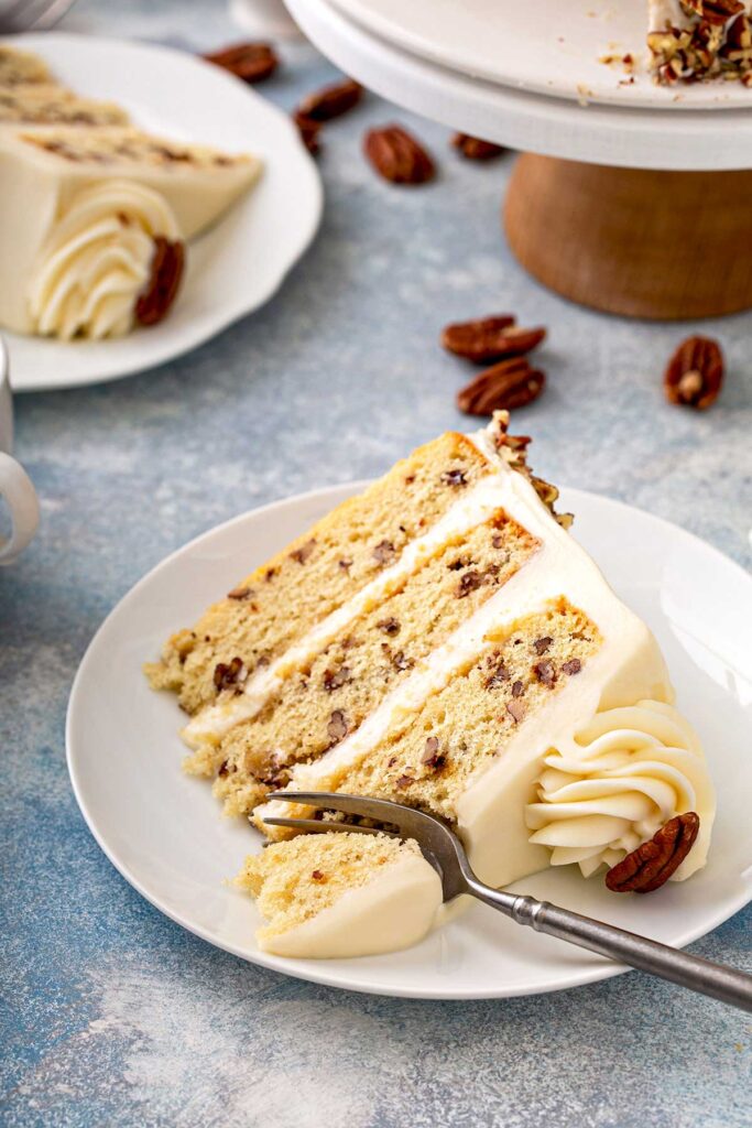 Sliced of layered butter pecan cake on a white plate