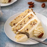 tender and irresistible layered vanilla cake with buttered pecans on a plate