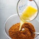 pouring melted butter over processed biscoff cookies