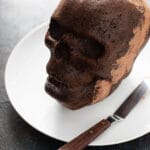 chocolate Skull cake with buttercream in the middle on a white plate