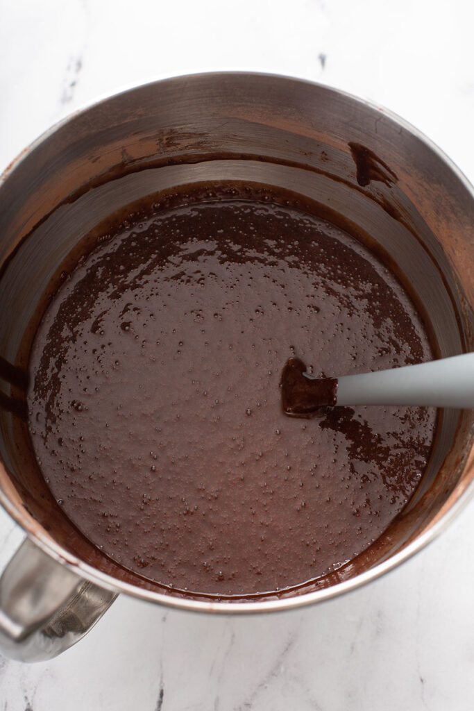 wet and dry ingredients mixed together in a bowl for this one bowl chocolate cake 