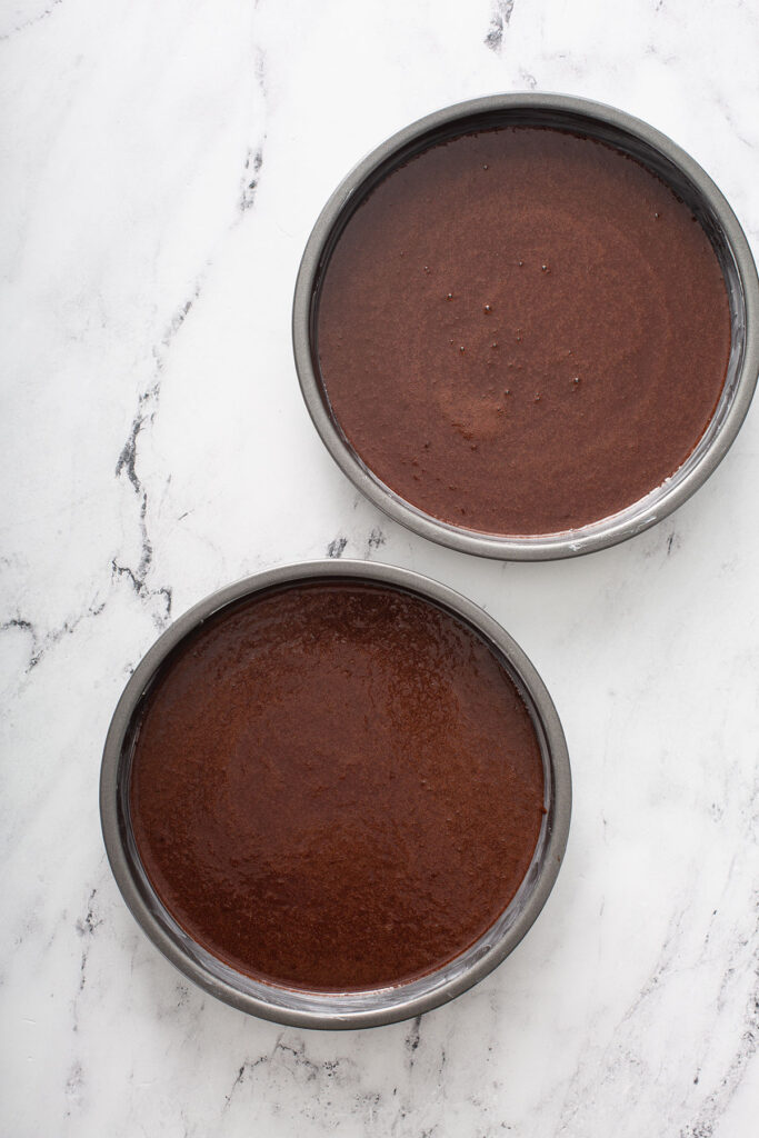 two prepped pans filled with chocolate mixture for this delicious chocolate cake. 