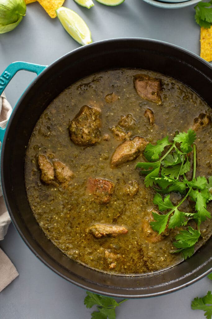 A pot filled with Mexican pork stew and garnished with fresh cilantro
