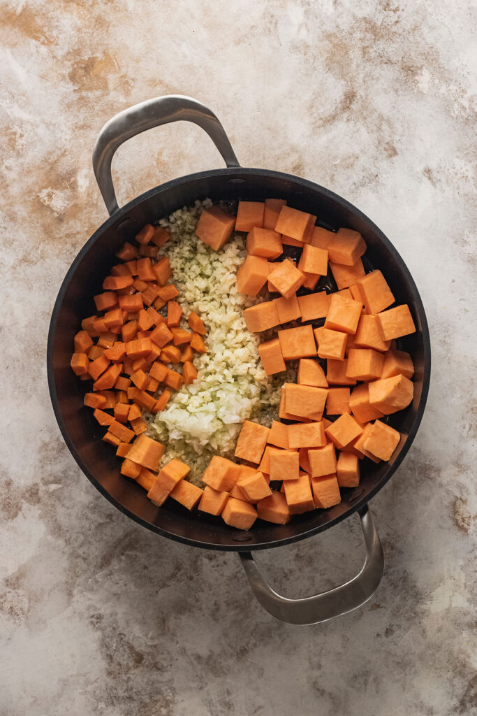Sweet potatoes, onions, carrots, and sugar in dutch oven for vegetarian chili