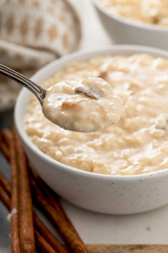 A spoonful of rice pudding is lift from a dessert bowl.
