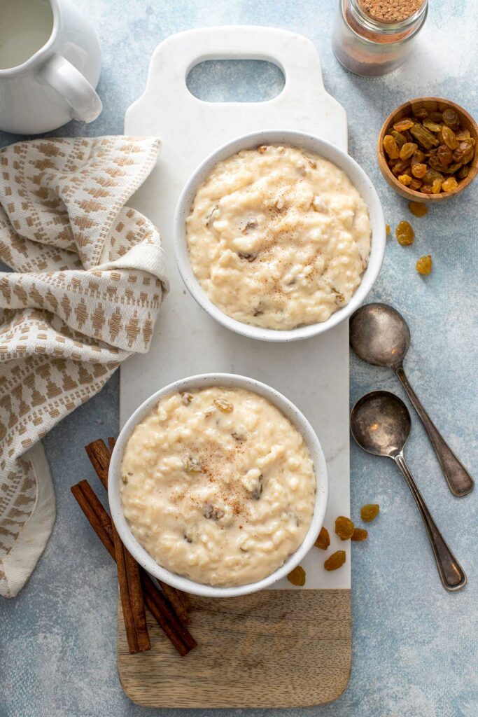 Bowls filled with creamy rice pudding with golden raisins.