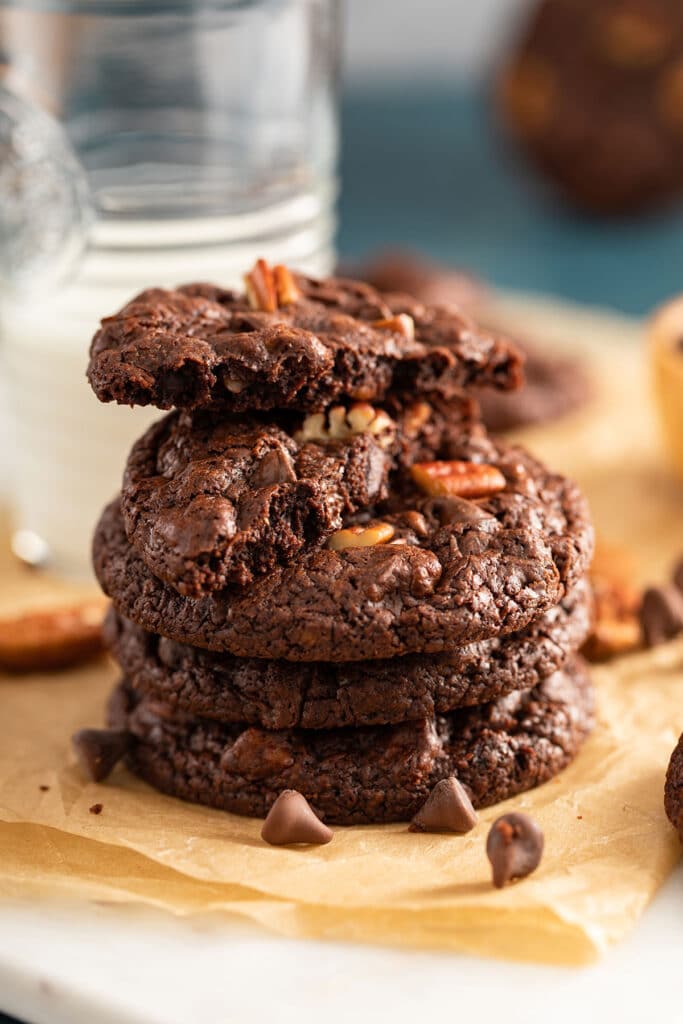 Stack of double chocolate cookies with chocolate chips and pecans.
