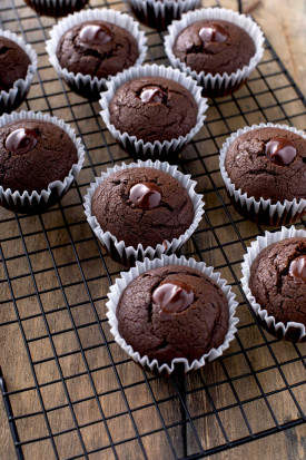 Chocolate cupcakes with Guinness ganache in the center on a cooling rack