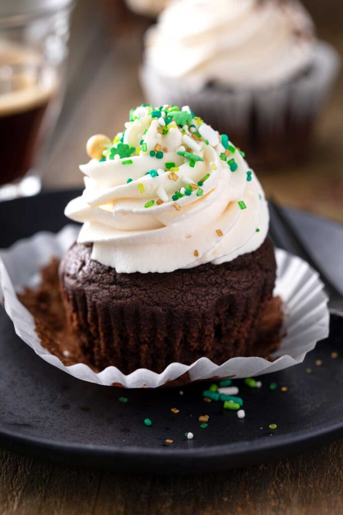 Chocolate cupcake frosted and decorated with green and gold  St. Patrick's day sprinkles.