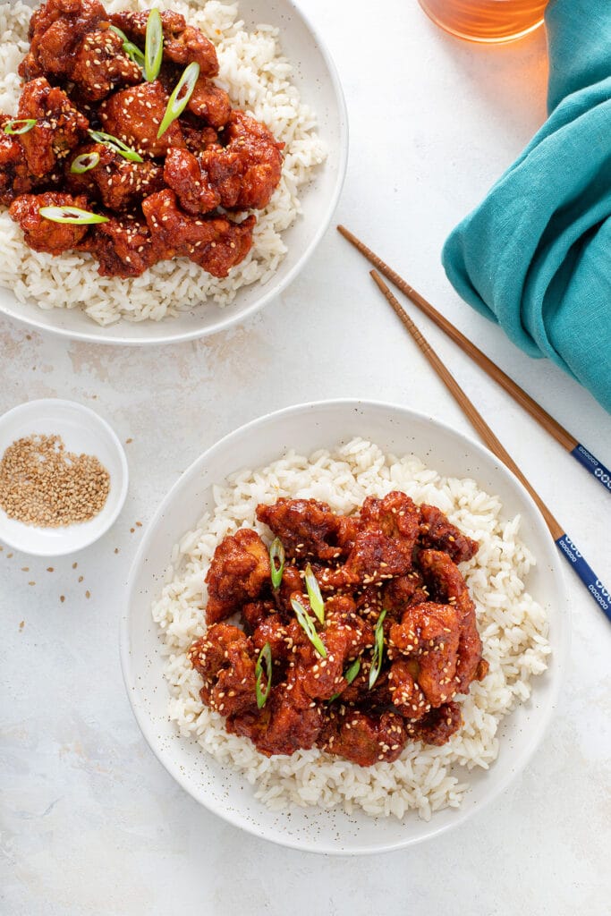 Plates with white rice topped with sweet and spicy Korean Fried chicken