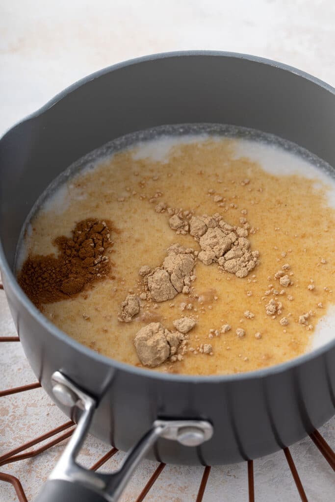 A small saucepan with milk, maca powder and cinnamon