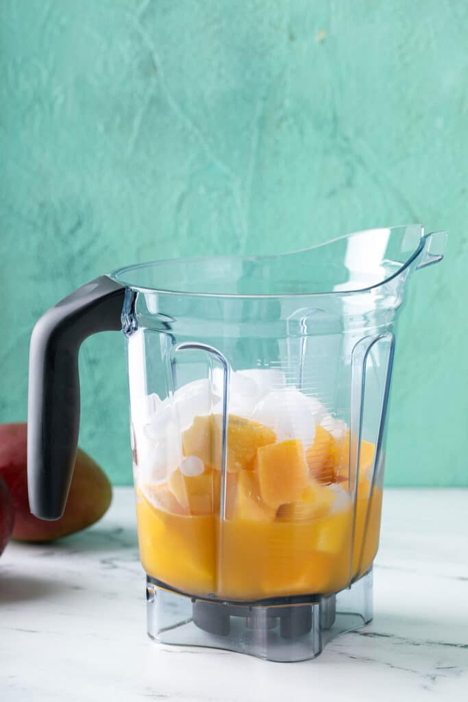 frozen mango, mango nectar, lime juice and ice into a blender.