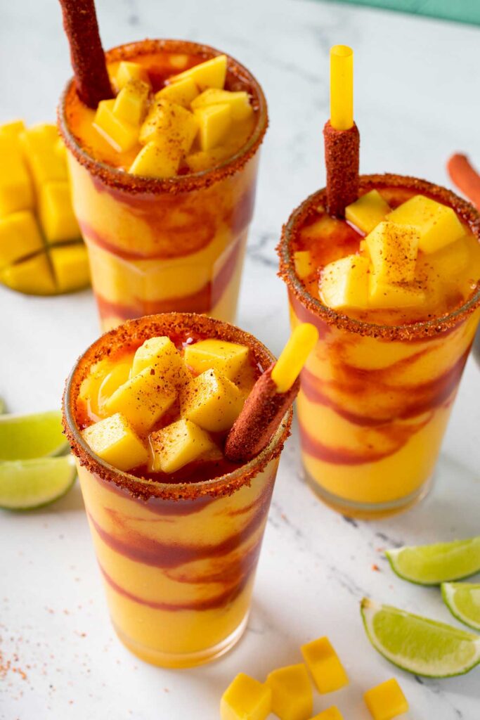 Top view of a glass with mangonada topped with tajin and mango chunks