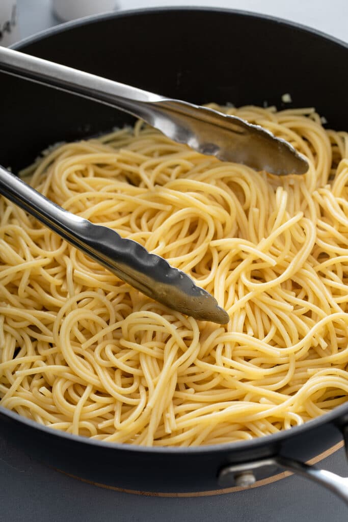 tossing noodles in the garlic butter that's been sauteed and then adding pasta water that's been reserved. 