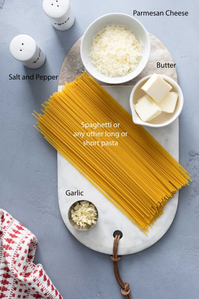 Group of ingredients needed to make butter pasta on a board