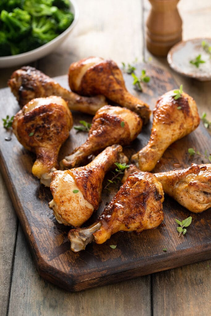 Golden brown oven baked chicken legs on a cutting board