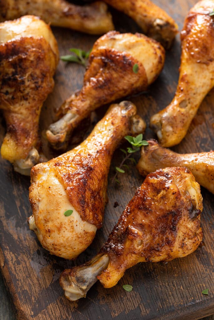 Succulent chicken legs with crispy skin on a wooden board