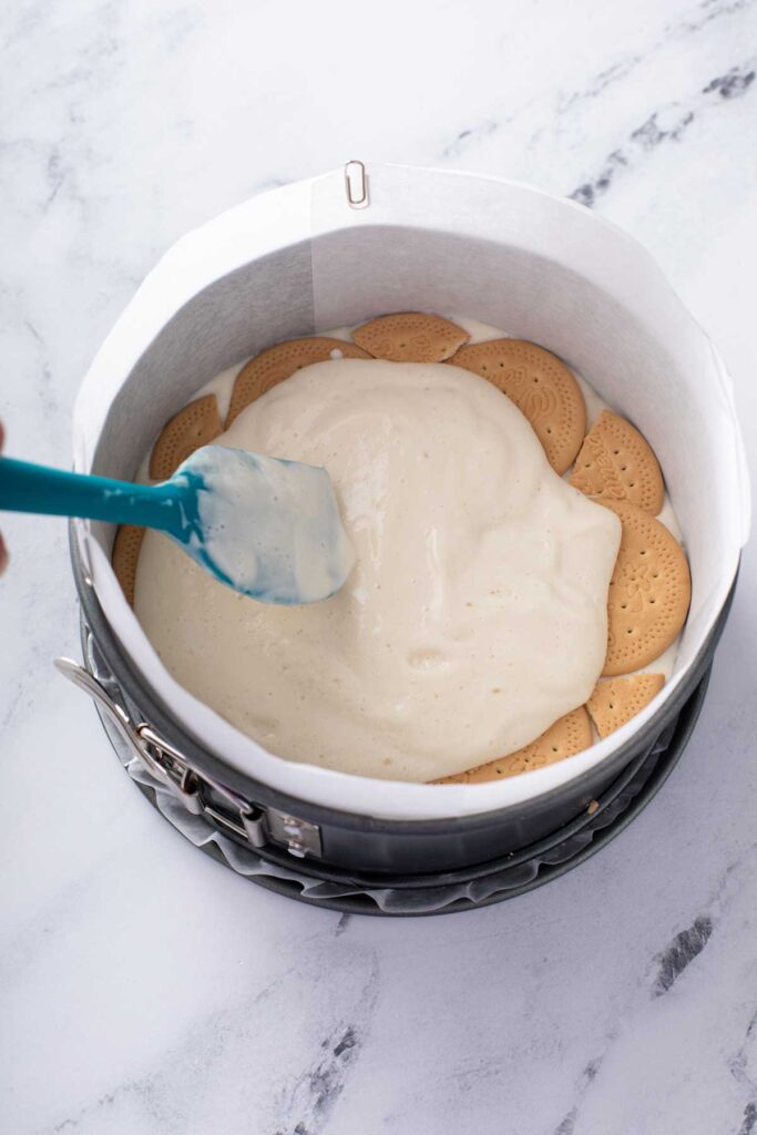 Delicious Cream filling being smoothed on top with spatula to make a layer of cream filling on top of marias galletas for this mexican icebox cake. 