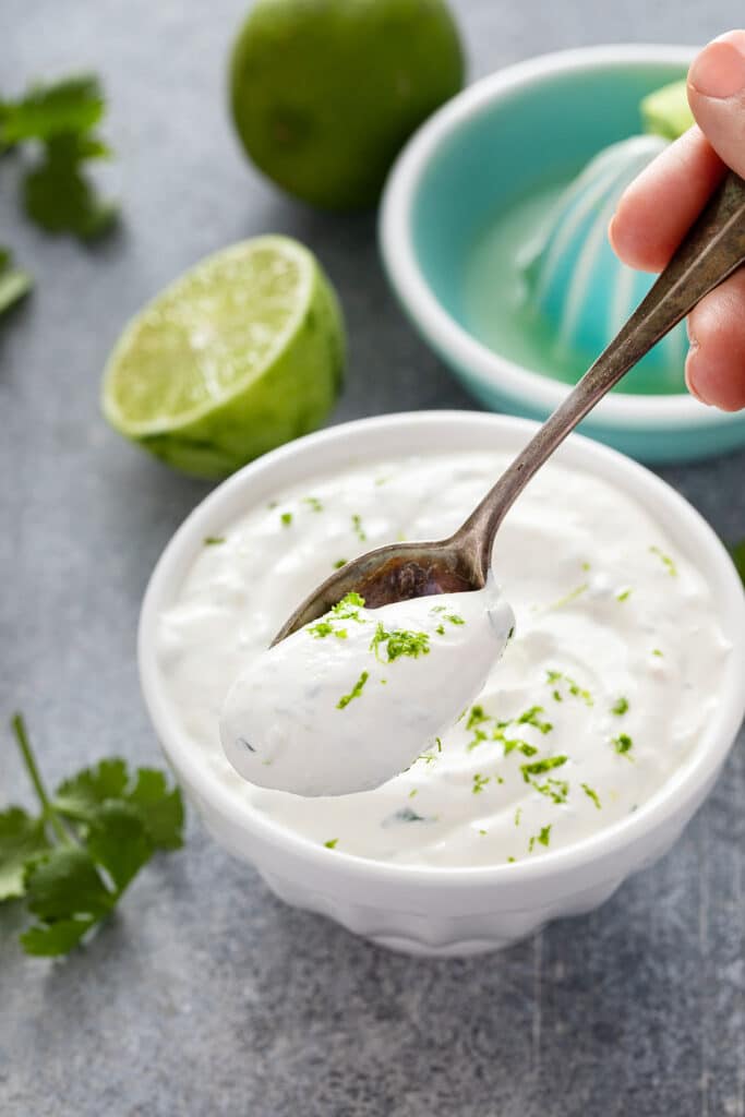 Spoonful of lime crema from a white bowl