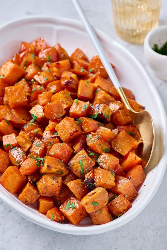 Close up view of Maple Oven Roasted Sweet Potatoes in a white bowl